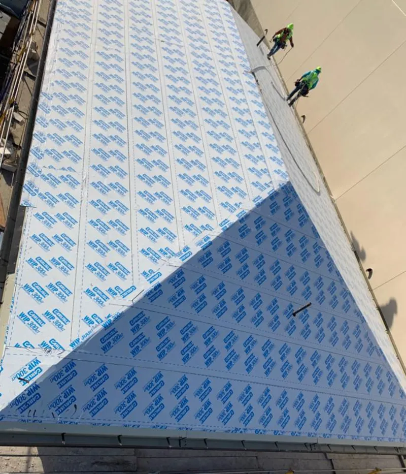 Professional roofers installing underlayment on a metal roof in Asheboro